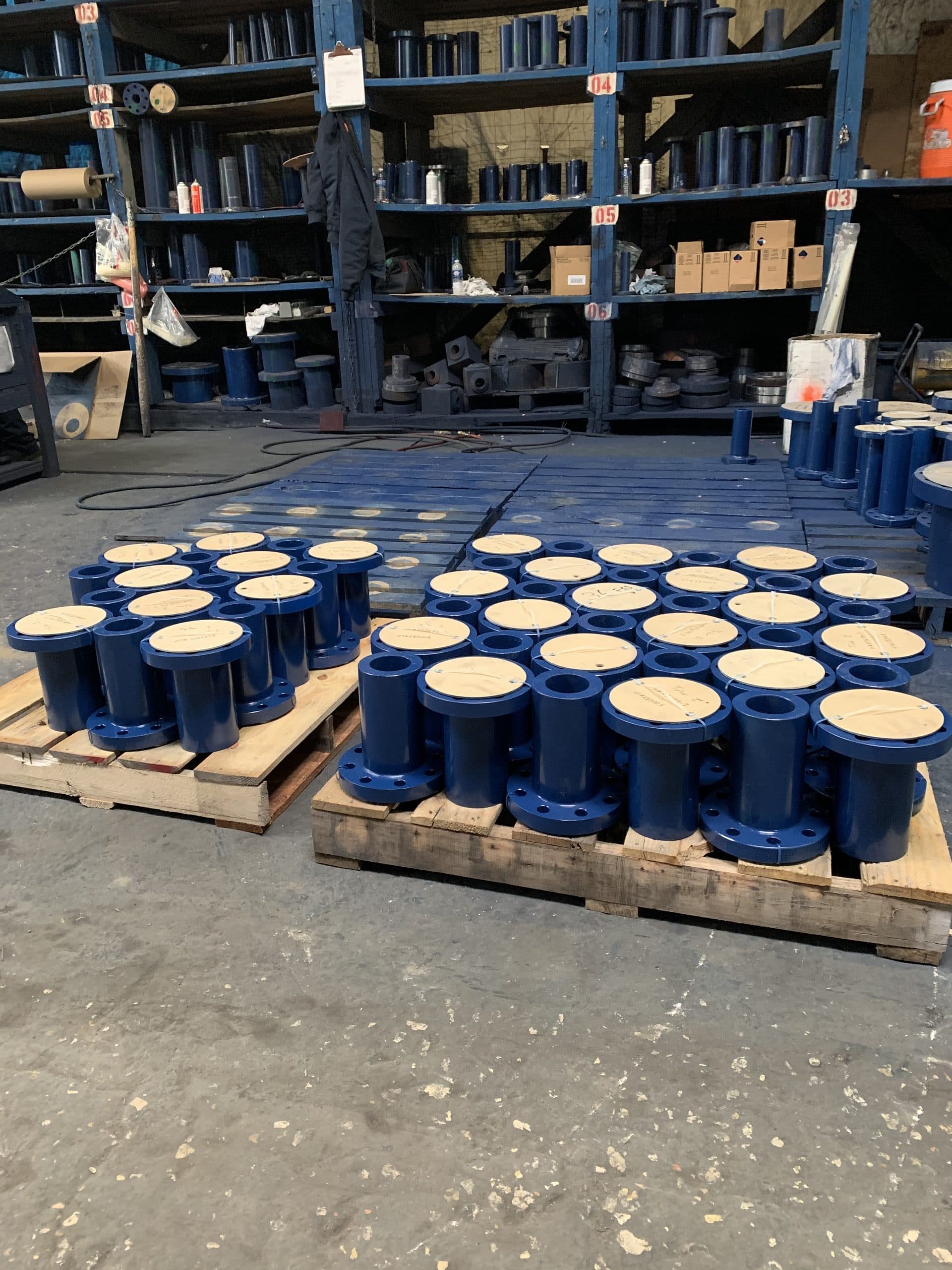 Pallets of blue long weld neck nozzles in the FCI warehouse