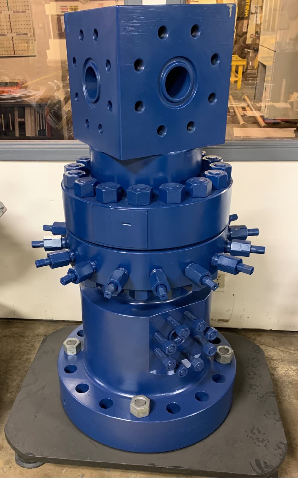 A tall blue wellhead stack with studded outlets
